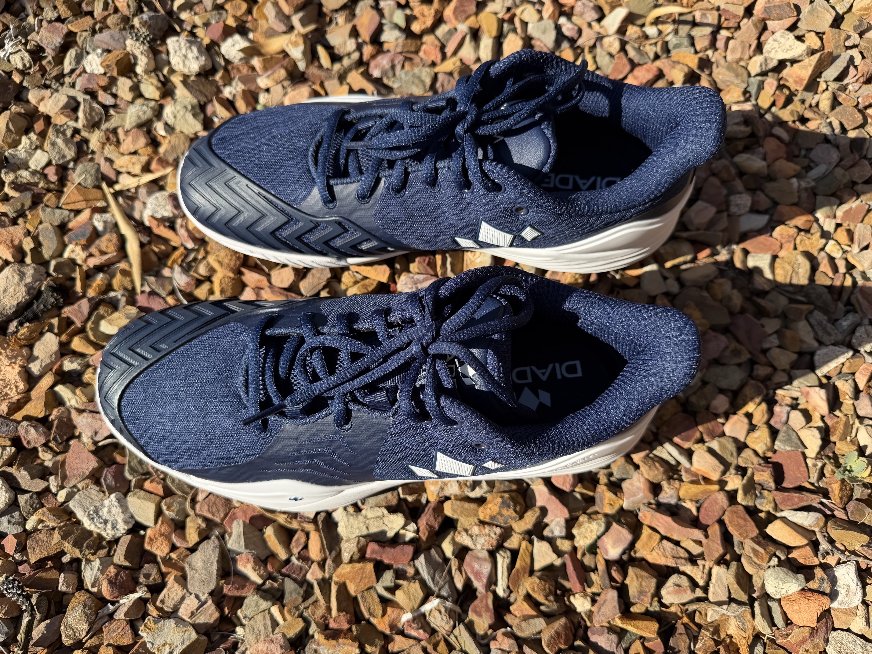 Top-down view of both Diadem Court Burst shoes in navy and white, showing the rounded anatomic toebox shape that splays in the 2E wide forefoot before tapering to a snug midfoot.